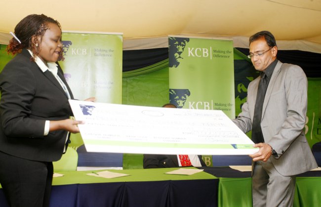 KCB Bank Director, Marketing and Communication, Angela Mwirigi hands over Ksh.9 million cheque toPGK Chairman, Charan Thethy for KCB Golf tour.(Photo by Shutterspeed)