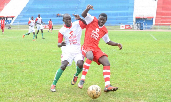 Laiser Hill's Musa Masika (red) vies for the ball with  a Muvuti opponent in the opening match of the championship